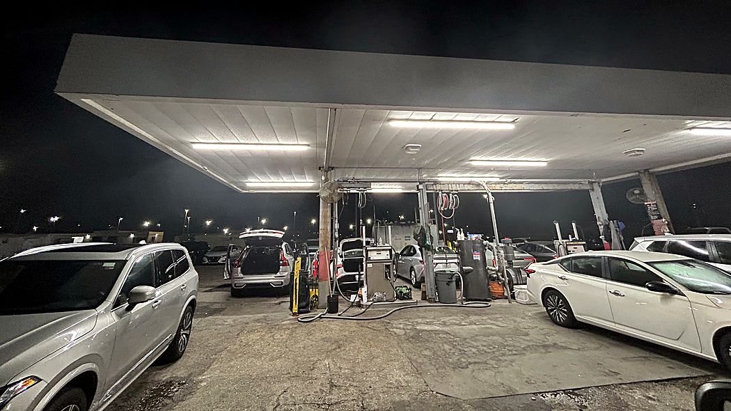 Gas station canopy lit by LED strip fixtures at night